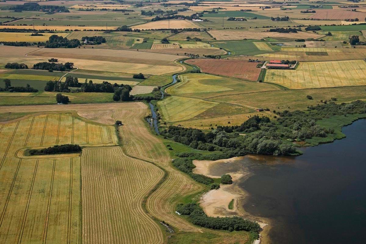 Billede af landområde med marker, gårde og en å